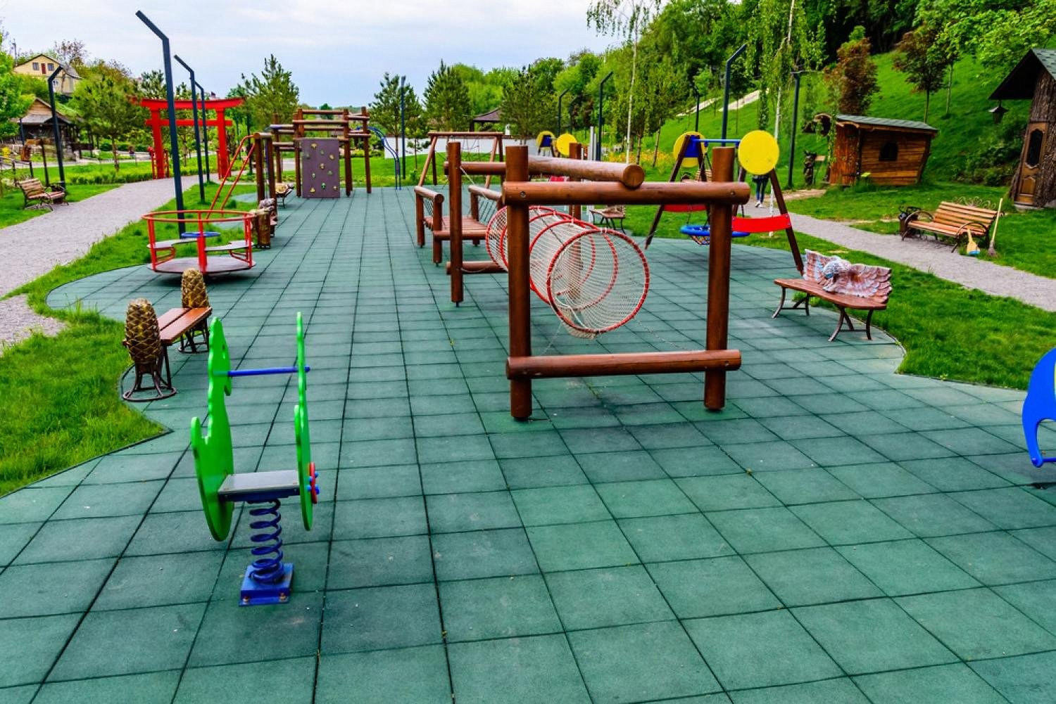 Colourful outdoor playground with climbing frames and safe rubber flooring